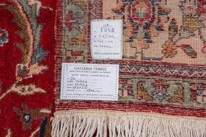 Galleria Tabriz - Tappeti in vendita. Primo piano di un angolo di un tappeto a motivi con due etichette che ne indicano l'origine, le dimensioni e altri dettagli.