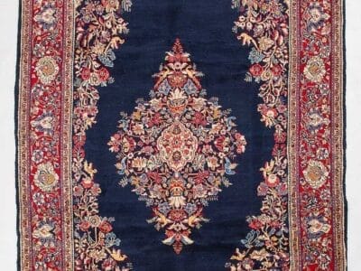 Galleria Tabriz - Tappeti in vendita. Tappeto persiano con centro blu scuro, motivi floreali ornamentali e un dettagliato bordo rosso e crema: un elegante Tappeto Saruk che mostra la bellezza senza tempo dell'artigianato Saruk Persia.