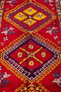 Galleria Tabriz - Tappeti in vendita. Tappeto Azari a motivi colorati con rombi geometrici in rosso, giallo, bianco e blu su un ricco sfondo rosso, ispirato ai disegni tradizionali della Persia.