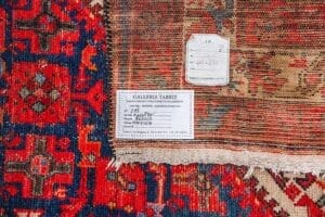 Galleria Tabriz - Tappeti in vendita. Primo piano di un tappeto colorato, probabilmente un Passatoia Malayer, con cartellini di identificazione e informazioni sulla galleria.