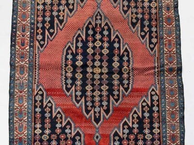Galleria Tabriz - Tappeti in vendita. Tappeto Zanjan d'epoca proveniente dalla Persia, questo tappeto persiano presenta motivi geometrici in rosso, nero e blu, evidenziati da un suggestivo motivo centrale a rombi.