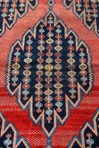 Galleria Tabriz - Tappeti in vendita. Motivo geometrico su tappeto Tappeto Zanjan a tessitura rossa e blu con disegni a rombi e a zig-zag, ispirato ai motivi tradizionali della Persia zanjana.