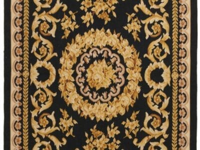 Galleria Tabriz - Tappeti in vendita. Un tappeto rettangolare con sfondo nero e intricati motivi floreali nei toni dell'oro e del beige, caratterizzato da un medaglione centrale e bordi decorati.