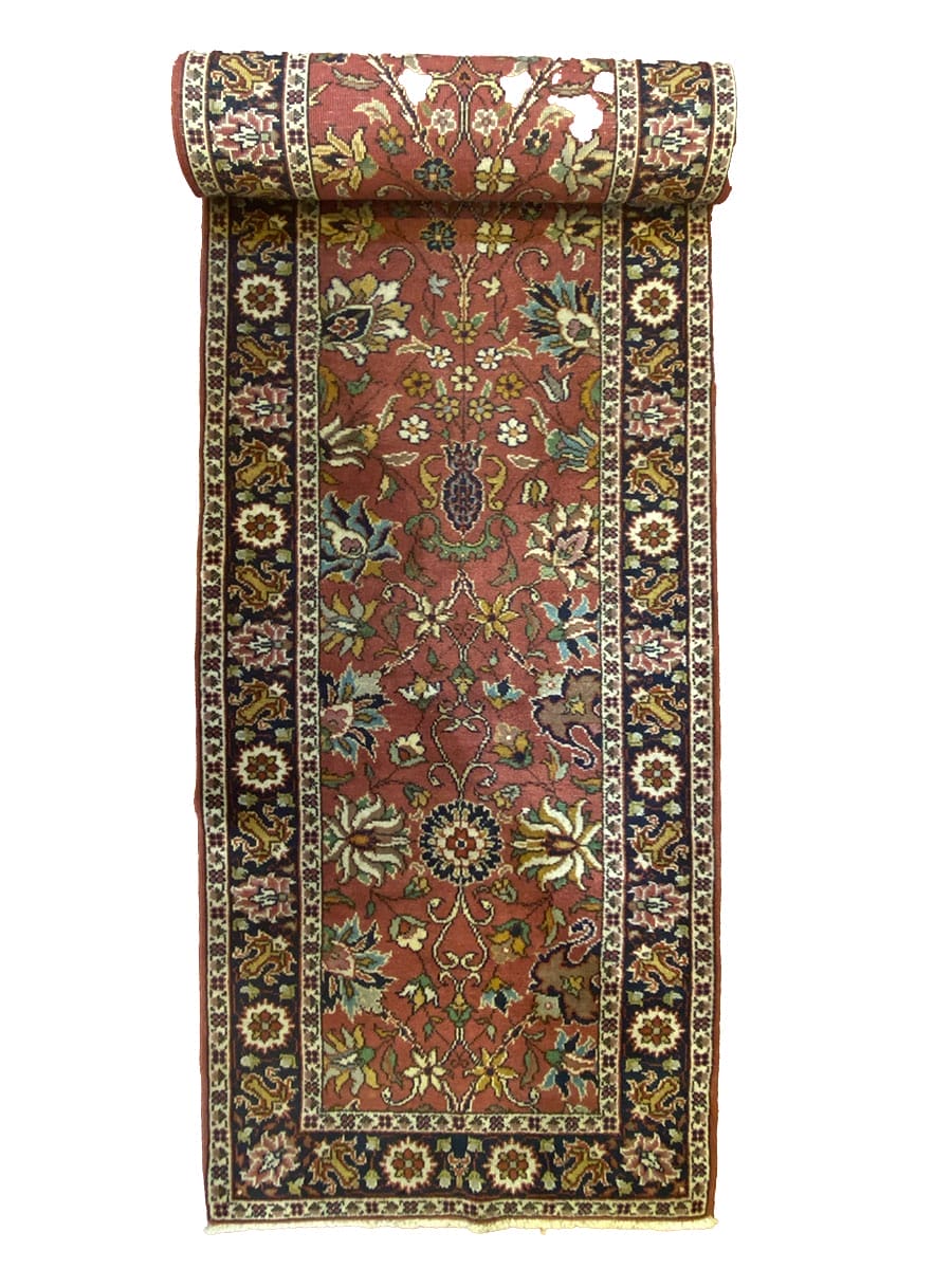 Un tappeto rosso e marrone con un disegno floreale.