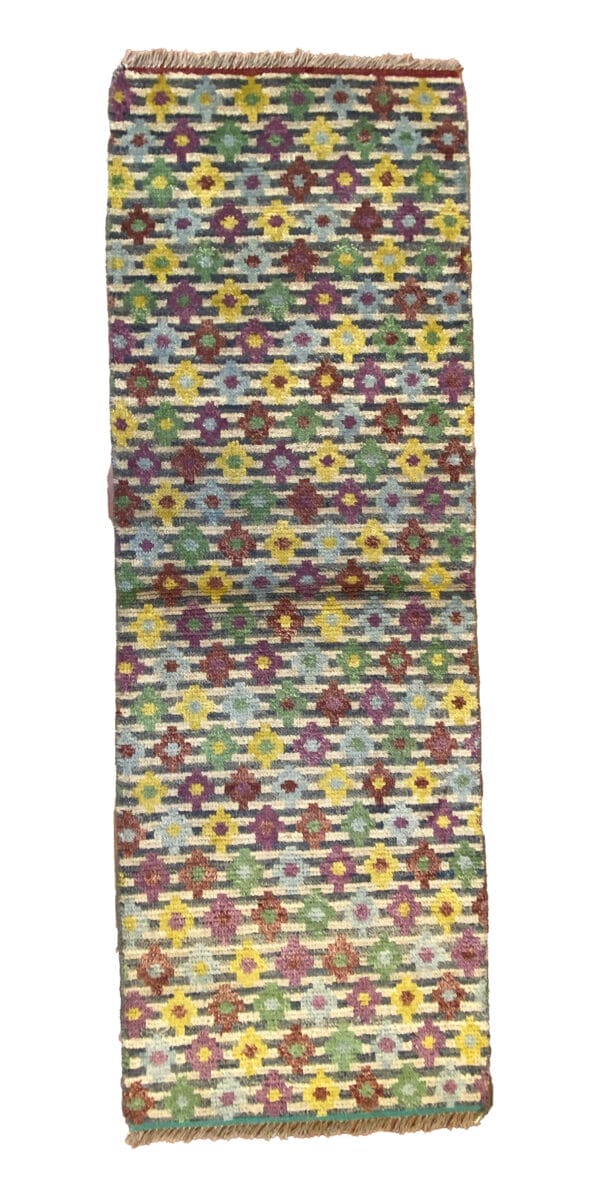 Un tappeto kilim colorato su sfondo bianco.