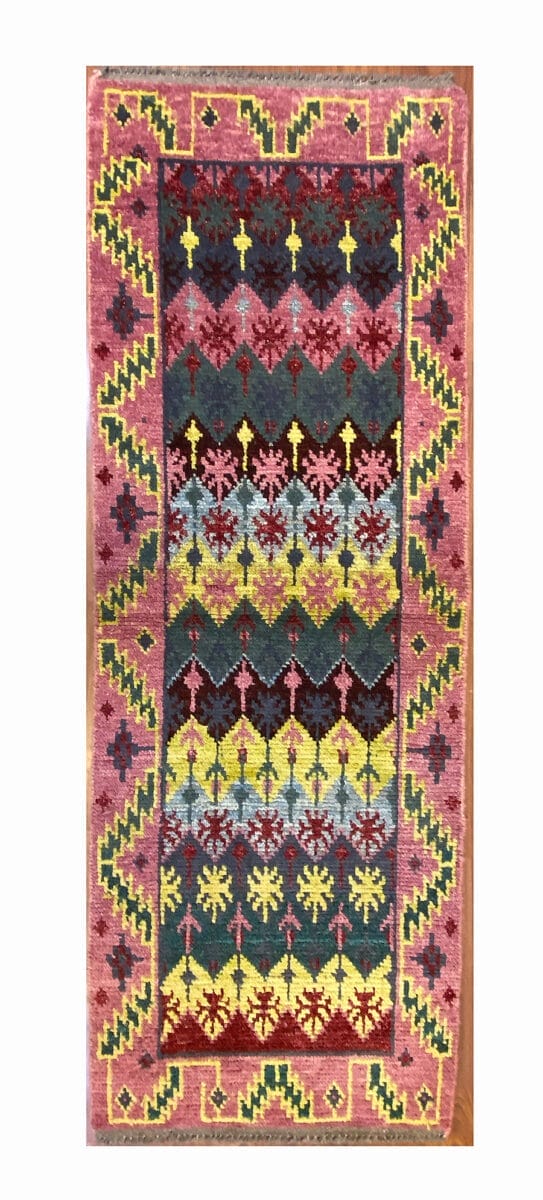 Un colorato tappeto kilim turco su un pavimento di legno.