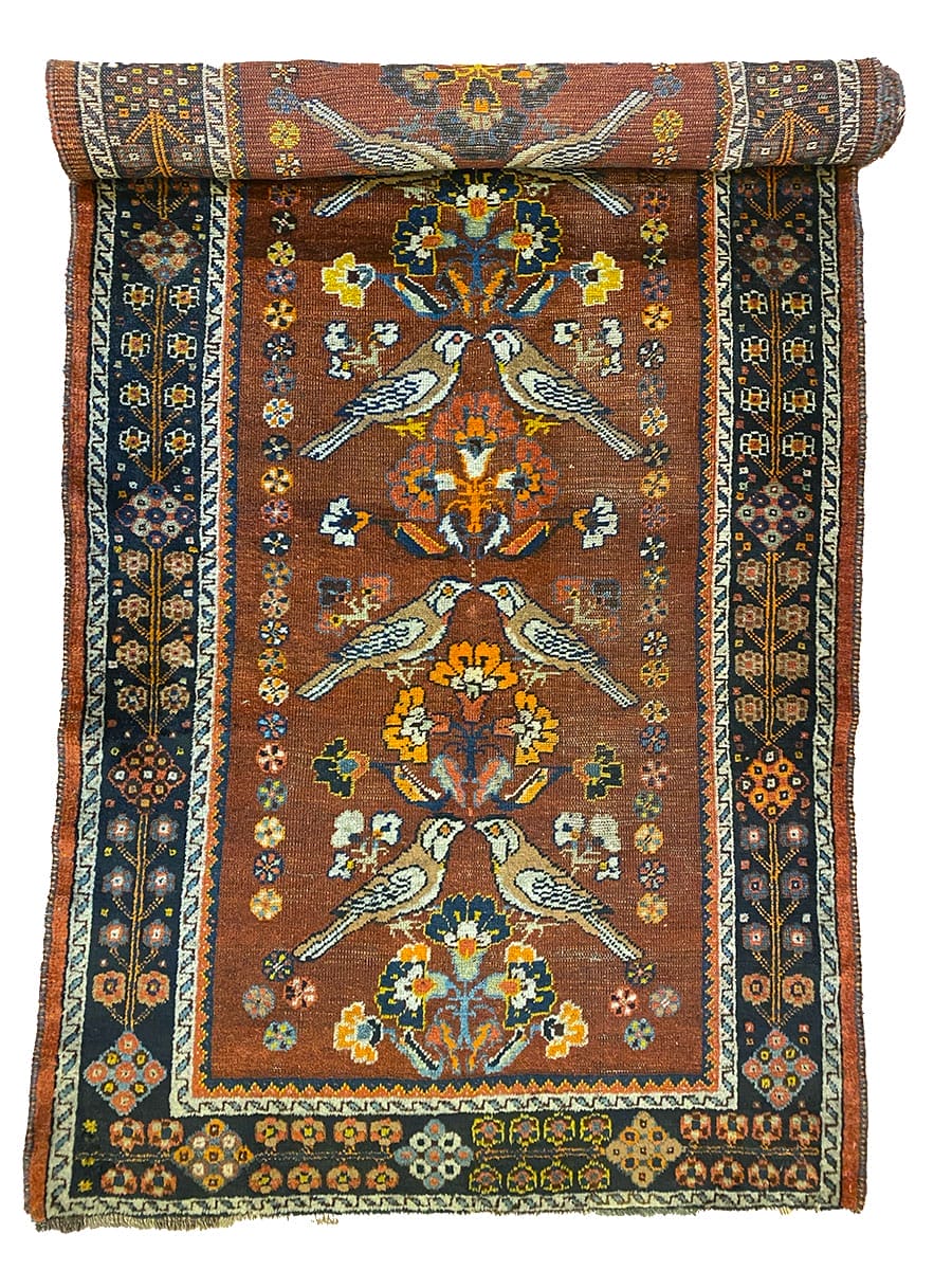 Un antico tappeto turco con sopra degli uccelli.