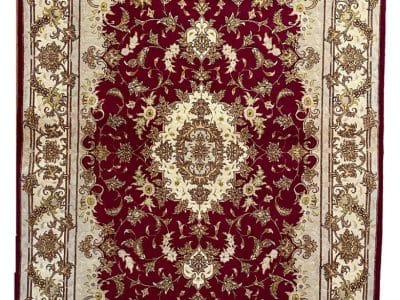 Un tappeto rosso e beige dal design ornato.