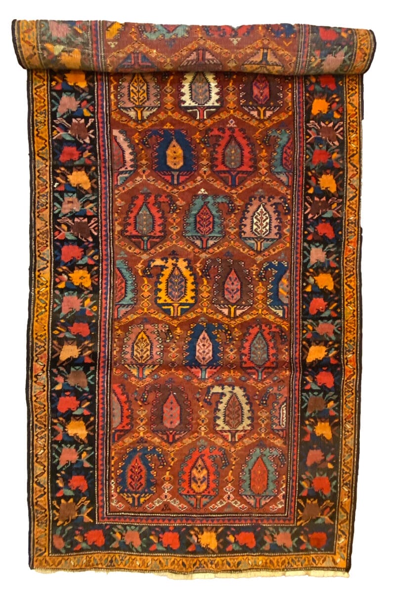 Un tappeto afgano antico con disegni colorati.