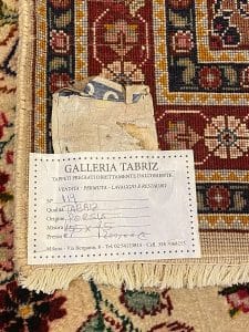 Un tappeto con un'etichetta sopra e un pezzo di carta.