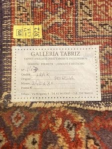 Un vecchio tappeto con un'etichetta sopra.